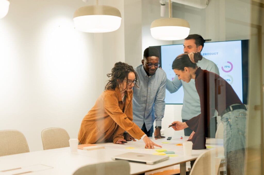 Team collaborating over sticky notes and plans at a meeting room table